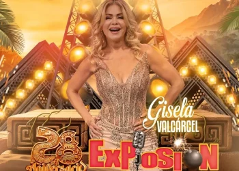 Gisela Valcárcel posa con vestido brillante frente a un fondo escénico iluminado, celebrando el 28 aniversario de Exposión en un entorno festivo con palmeras y arquitectura estilizada